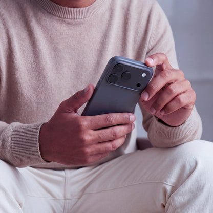 iPhone en coque ORIGINAL Noir fumé tenu à deux mains, vue du dos