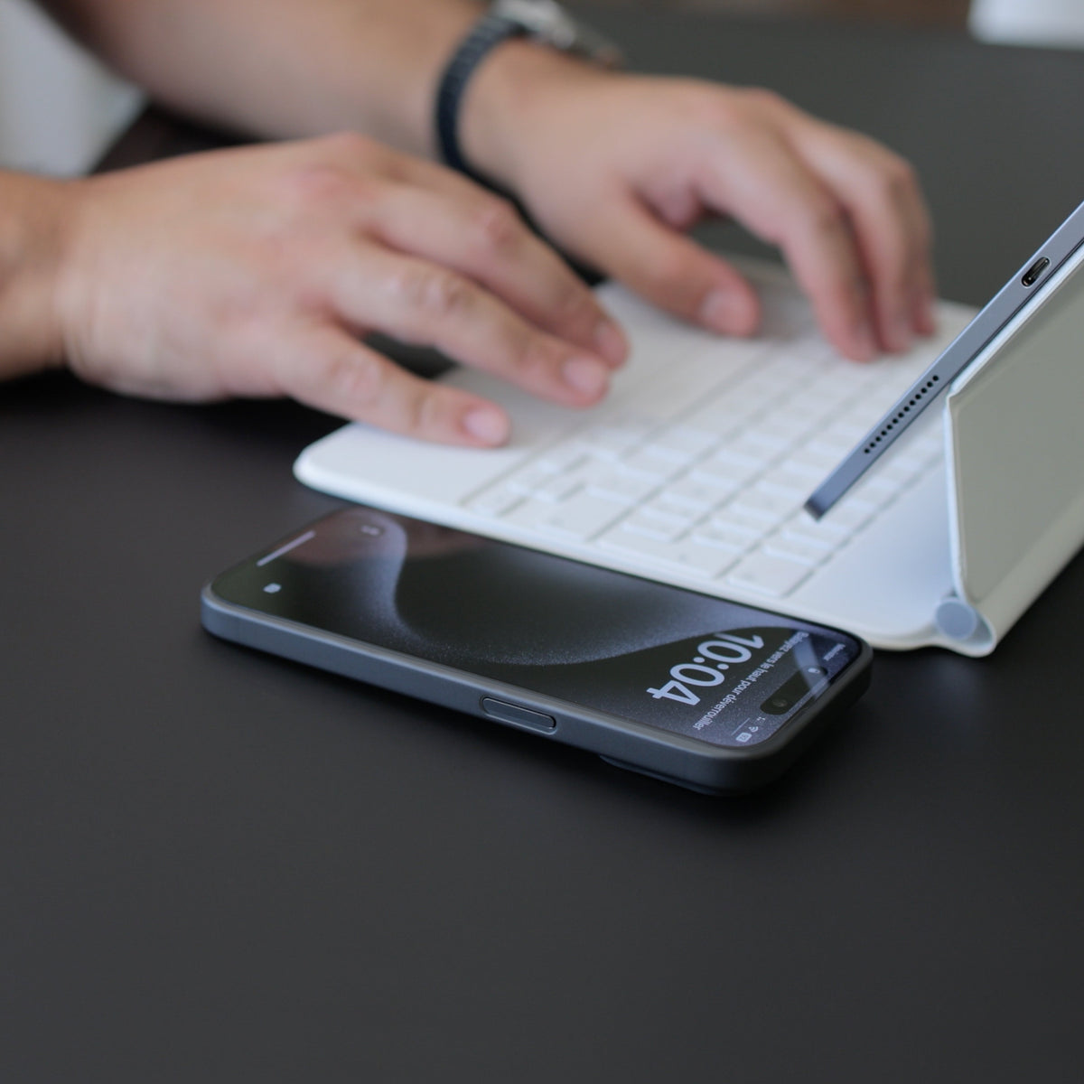 Téléphone posé à côté d'un clavier et d'une tablette sur un bureau, écran protégé
