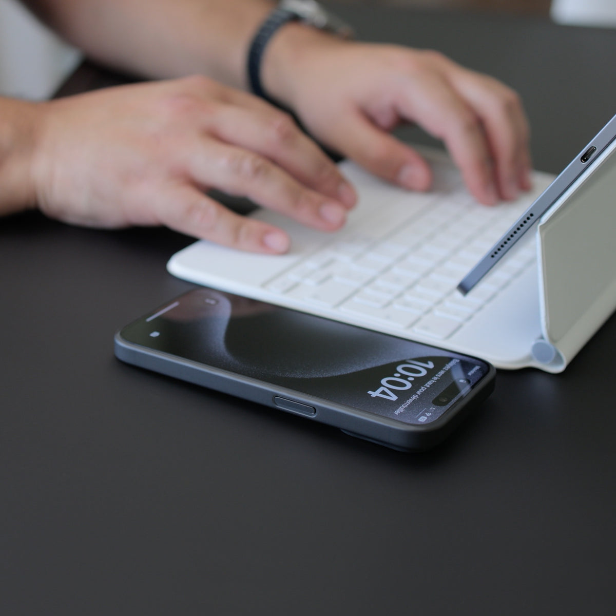 Téléphone posé à côté d'un clavier et d'une tablette sur un bureau, écran protégé